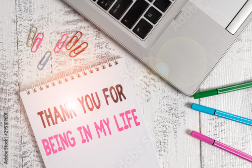 Handwriting text Thank You For Being In My Life. Conceptual photo loving someone for being by your side Slim metallic laptop blank spiral notepad pens clips lying wooden table photo