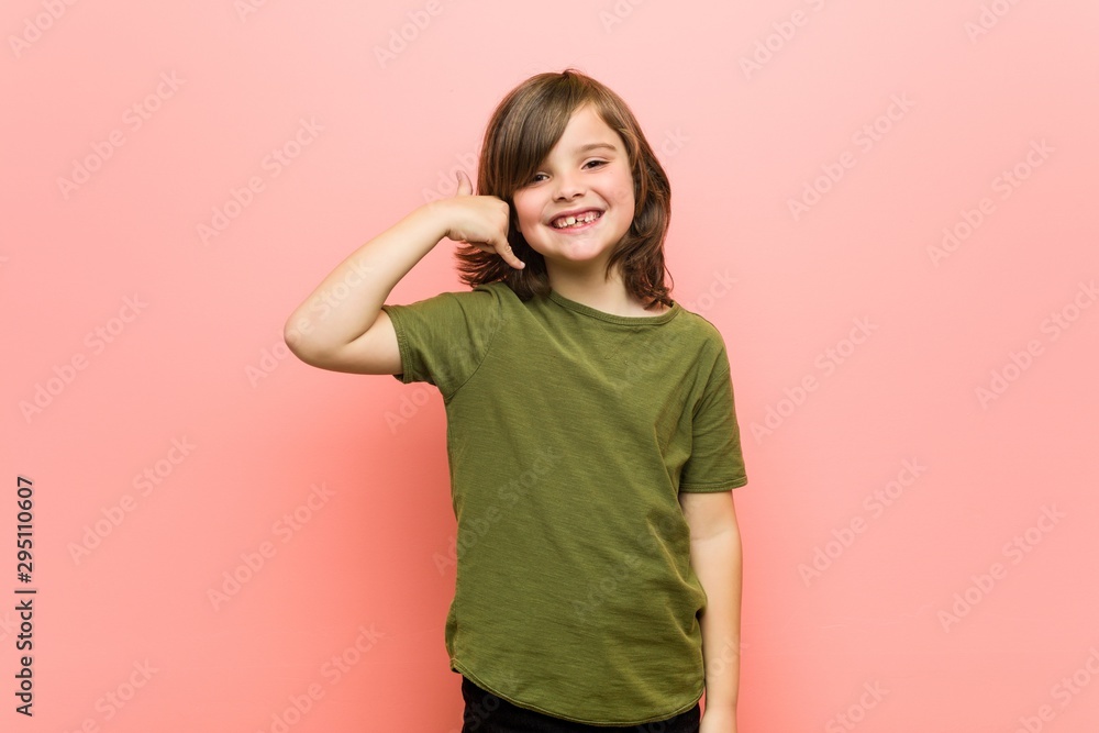 Little boy showing a mobile phone call gesture with fingers. Little boy showing a mobile phone call gesture with fingers.