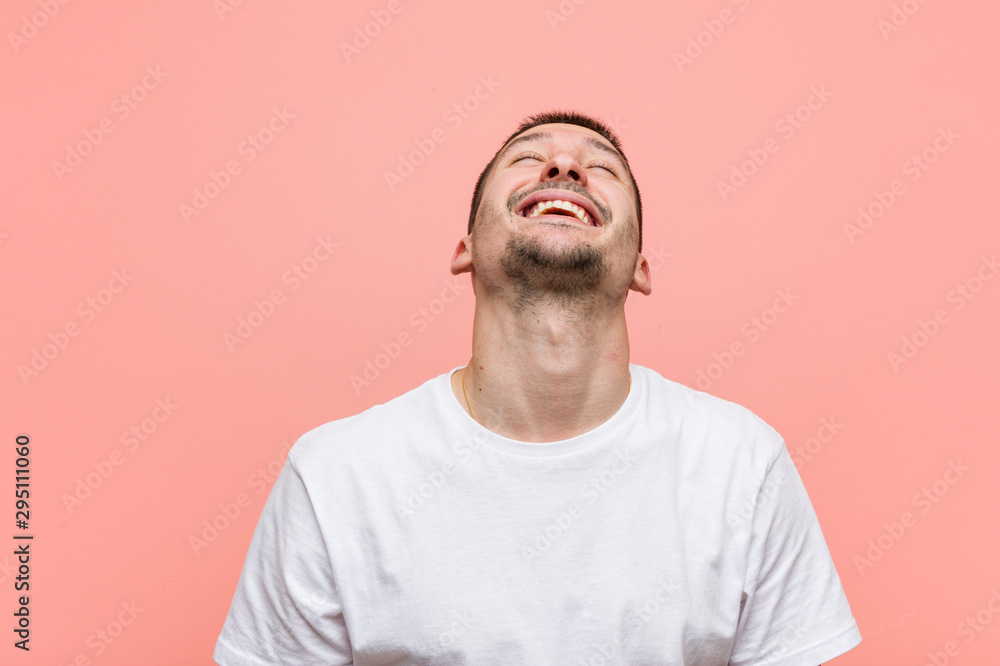 Young casual man relaxed and happy laughing, neck stretched showing teeth. Young casual man relaxed and happy laughing, neck stretched showing teeth.