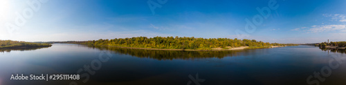 Panorama over the water surface to the autumn forest