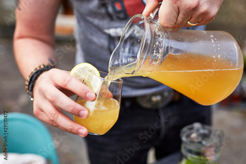Ginger and coriander seed shandy being poured from a jug into a glass