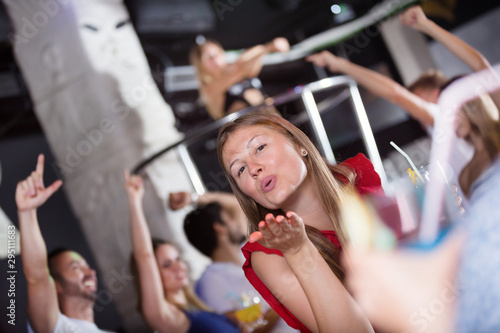Woman dancing in the night club with drinks