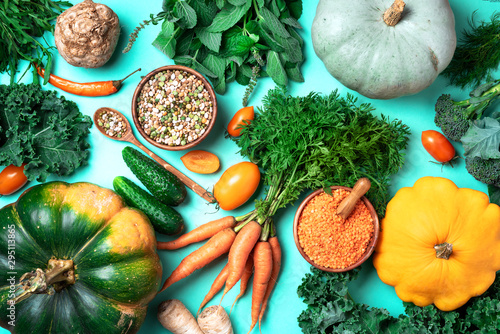 Organic vegetables, lentils, beans, raw ingredients for cooking on trendy green background. Healthy, clean eating concept. Vegan or gluten free diet. Copy space. Top view. Food frame
