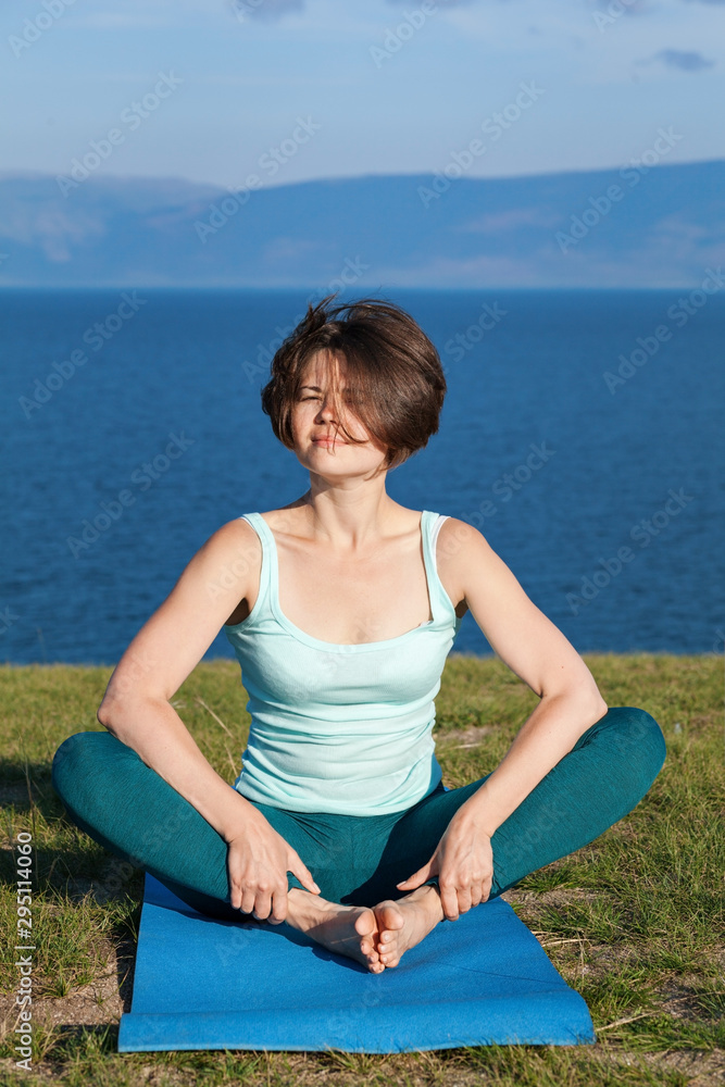 Beautiful young girl practicing yoga on the lake Beautiful young girl practicing yoga on the lake