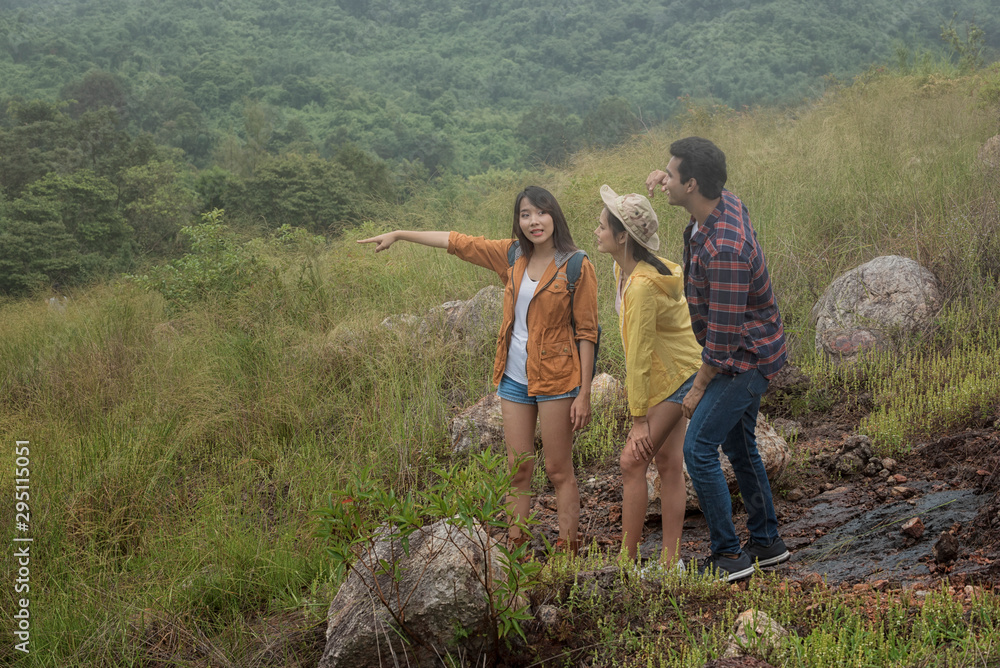 Group of friends on hike pointing away at a view. Young people hiking on extreme terrain on a summer day. Group of friends on hike pointing away at a view. Young people hiking on extreme terrain on a summer day.