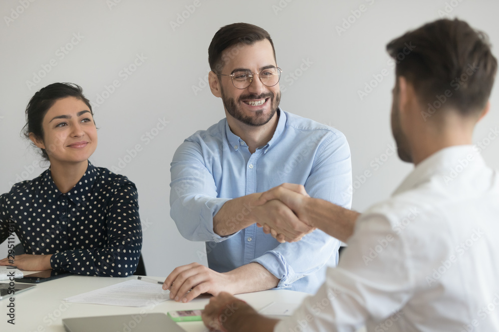 Fototapeta premium Smiling male hr manager handshake applicant at job interview