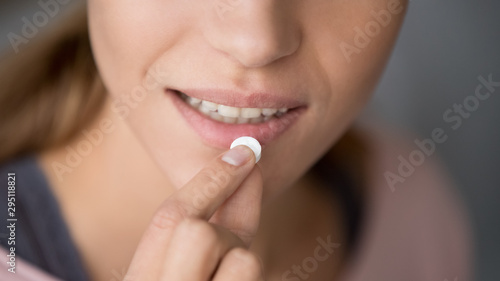 Young woman holding pill take meds, close up view