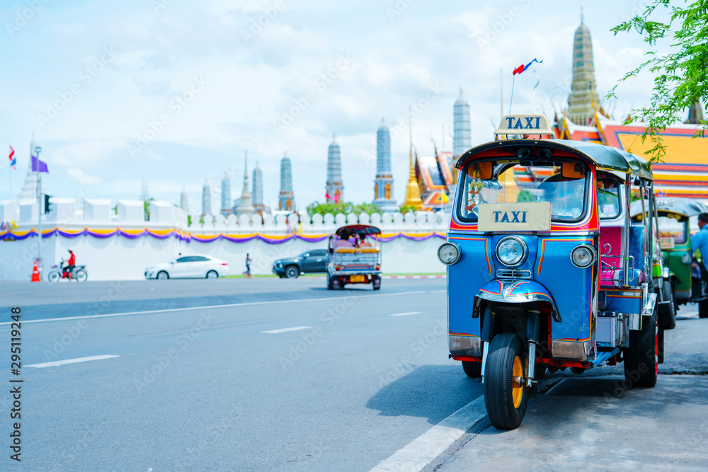 Fototapeta premium azja lokalna podróż w działalności miasta z lokalną taksówką (tuk tuk) parkingiem na czekanie na turystykę na ulicy bangkoku Tajlandia z tłem wielkiego pałacu