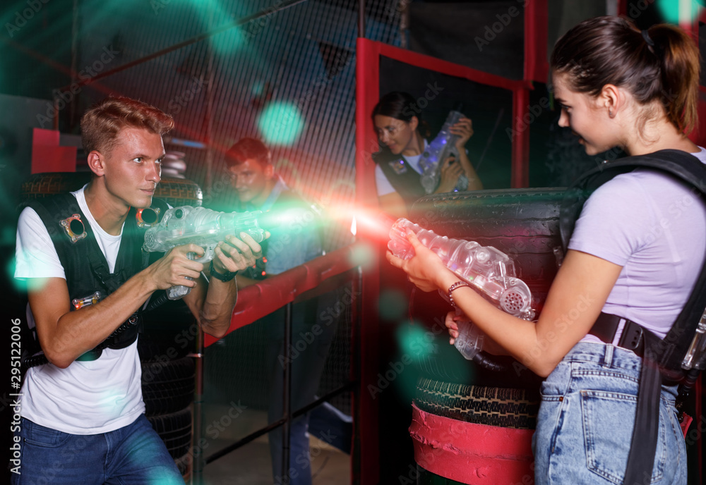 Group of  young people with laser guns playing laser tag  game