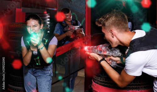 friends holding colored laser guns during laser tag game