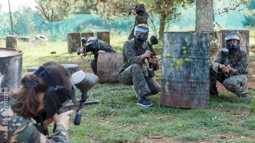 circumspect teams facing on battlefield in outdoor paintball arena