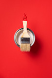 Brush and open paint can on trendy red background. Top view, copy space. Appartment renovation, repair, building and home design concept.