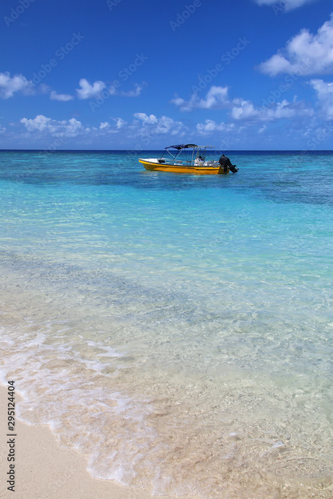 Tourist boat anchored at Gee island in Ouvea lagoon, Loyalty Islands, New Caledonia