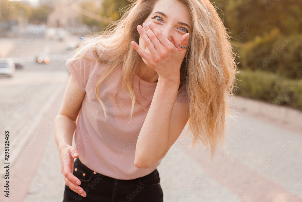 Young woman having fun and laughing in the city under the sunlight