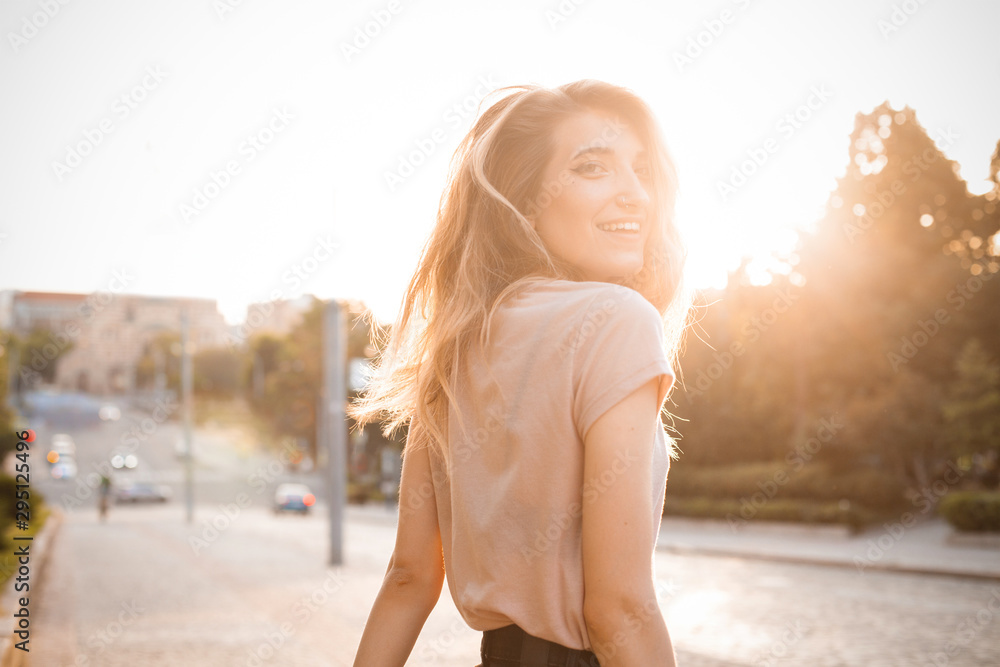 © Dima Aslanian - Happy woman woman with beautiful hair walking in the city under sunlight. Turn around