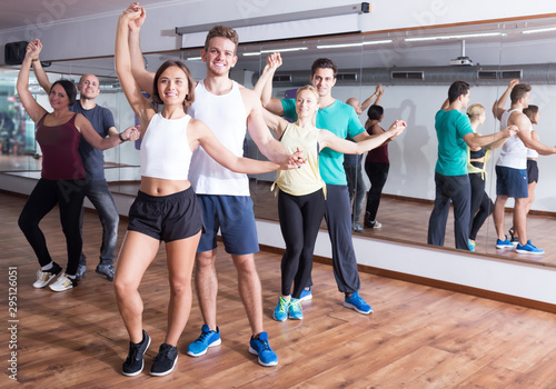 Group of smiling people dancing salsa together