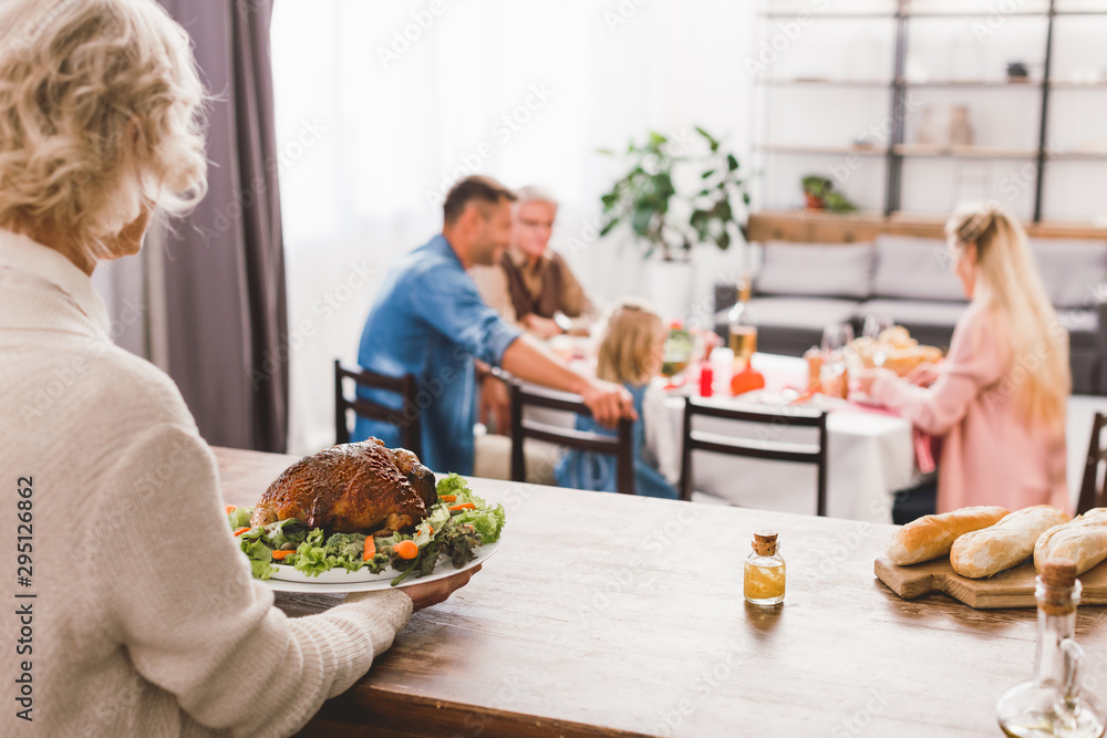 selective focus of grandmother holding plate with tasty turkey in Thanksgiving day selective focus of grandmother holding plate with tasty turkey in Thanksgiving day
