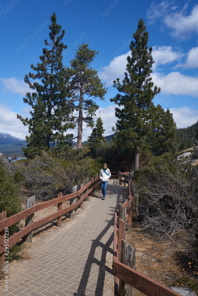 Lady tourist walking along the walkway in Sand Harbor State Park in Lake Tahoe Lady tourist walking along the walkway in Sand Harbor State Park in Lake Tahoe