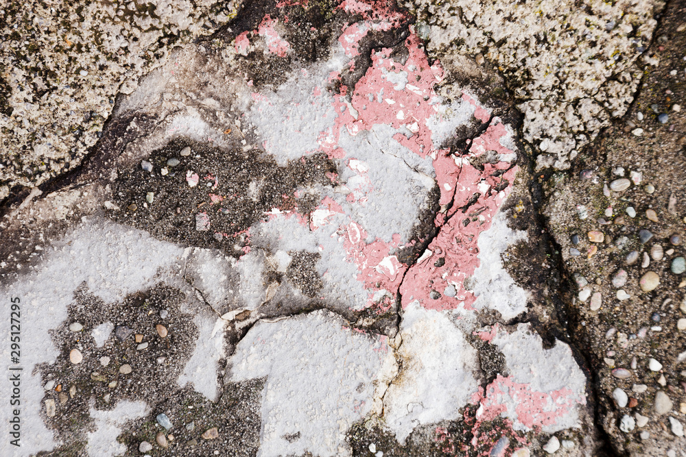 Naklejka premium cracked dirty stone wall with red, gray and dark gray pieces, concrete wall brocken and weathered with structure