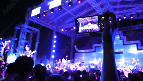 Foto People live with mobile phone at a festival concert with crowd people raised hands and attending a concert