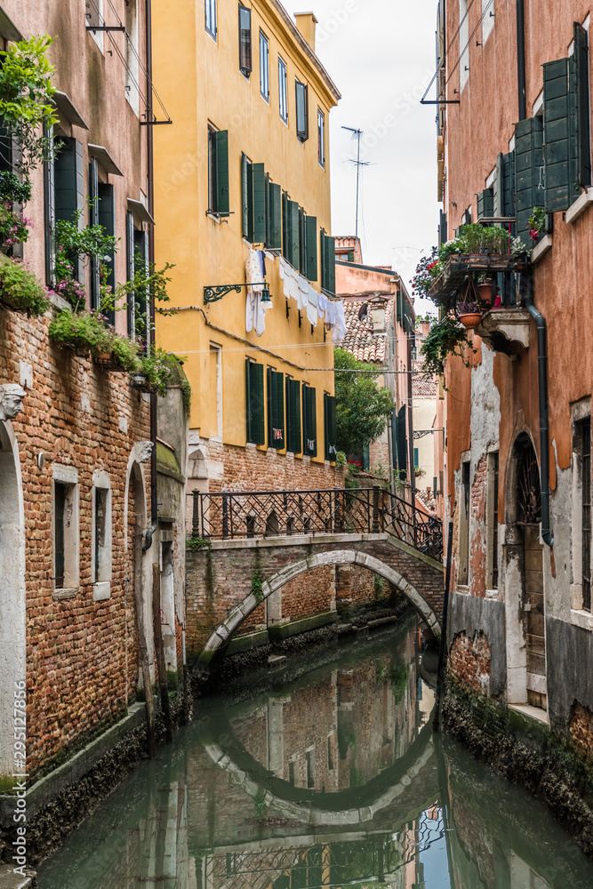 Reflection of the bridge in the narrow Venetian canal