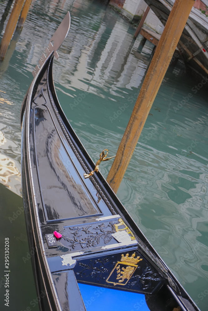 Front of the gondola, figurine on the nose of the gondola, gondola on the canal, Venice, close-up