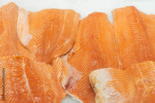 Fillet of salmon to portions close-up on ice in supermarket. Sale of seafood, fish. Open showcases , counter of seafood market