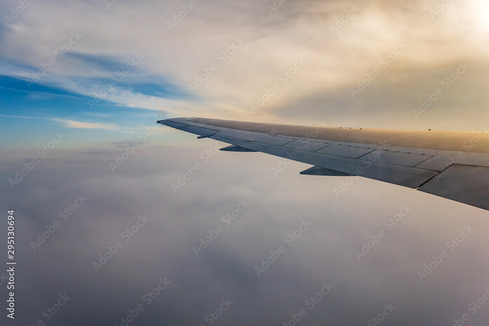 wing of airplane flying above clouds wing of airplane flying above clouds