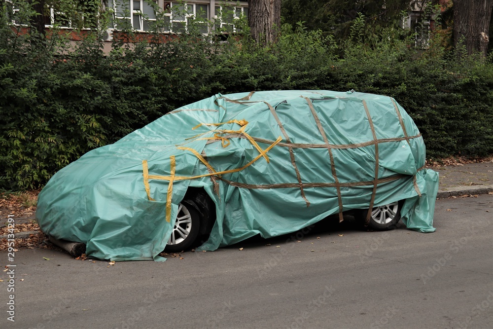 The car after the accident covered with plastic wrap and tied with tape