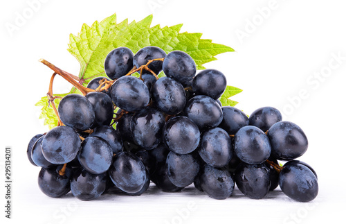 Ripe dark grapes on white surface close up