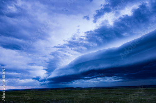 Spectacular supercell thunderstorm over green grassland.