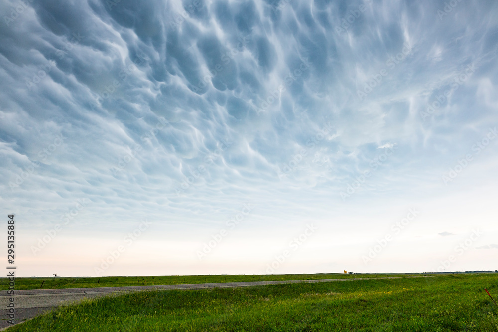 Fototapeta premium Mammatus clouds over green countryside.