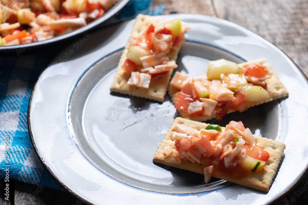 Surimi crab ceviche with cucumber and tomato on wooden background