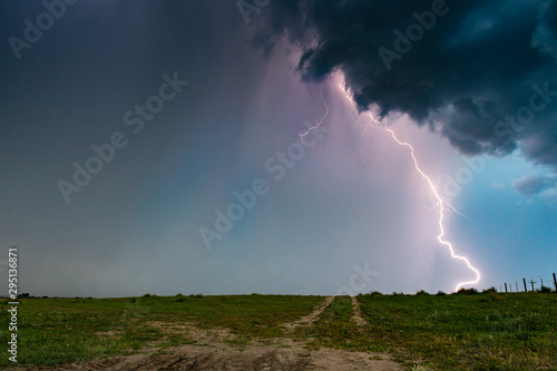 Dramatic bolt of lightning hitting the ground from supercell thunderstorm