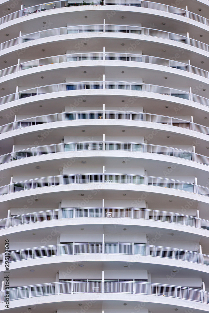 White balcony of hotel exterior a modern circular building of and glass windows.