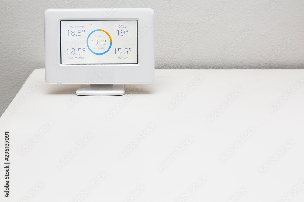 A wireless thermostat showing the temperatures in different rooms of a house. A wireless thermostat showing the temperatures in different rooms of a house.