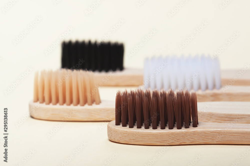 Four eco-friendly bamboo toothbrushes on a yellow background. Zero waste concept, plastic-free, organic, eco-friendly shopping Four eco-friendly bamboo toothbrushes on a yellow background. Zero waste concept, plastic-free, organic, eco-friendly shopping