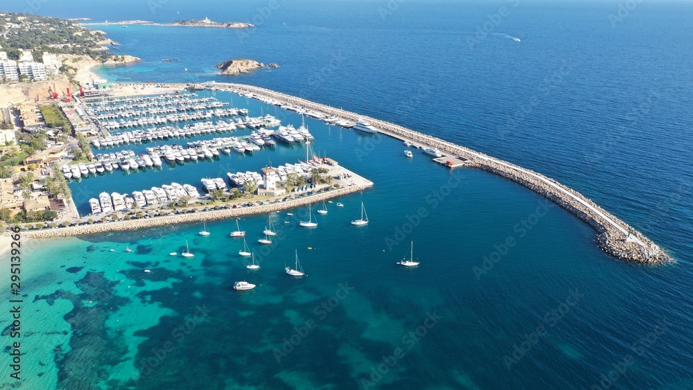 Wonderful aerial photography of the coast of Mallorca, with a luxury yacht in front of the famous Portals harbor, overlooking the mountains  