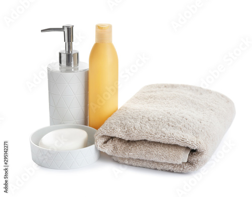 Folded soft towel and toiletries on white background