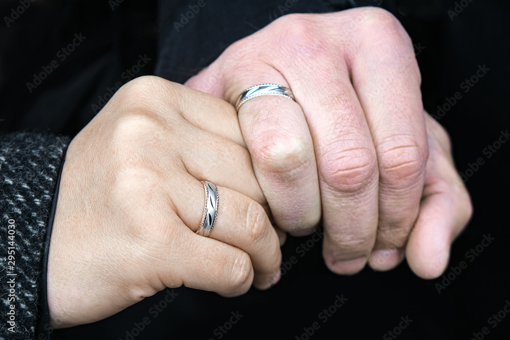 Wedding rings on his hands. An elderly couple got married. Happy family. Family outdoors.