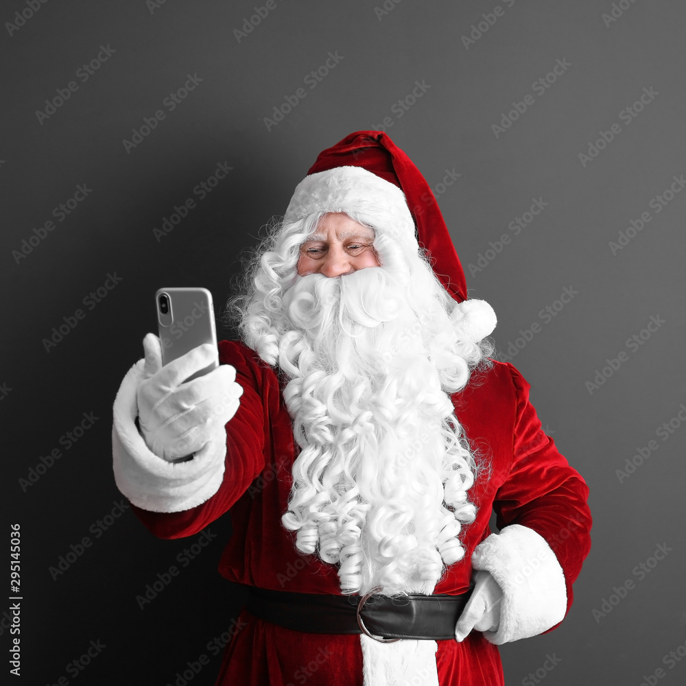 Authentic Santa Claus taking selfie on grey background