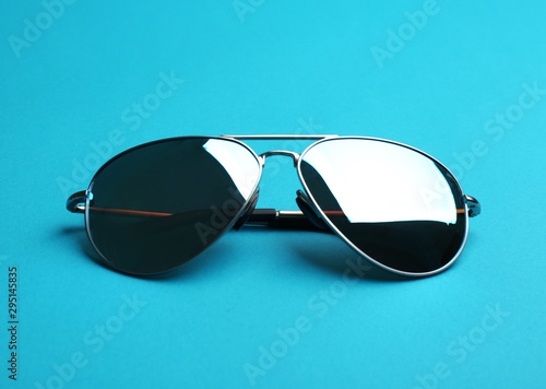 Stylish sunglasses on blue background. Fashionable accessory
