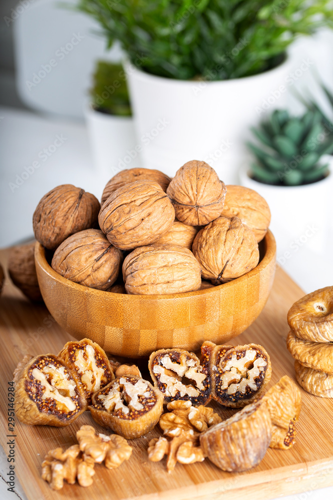 Whole walnuts in bowl. Dried figs with walnuts on wooden background. Whole walnuts in bowl. Dried figs with walnuts on wooden background.