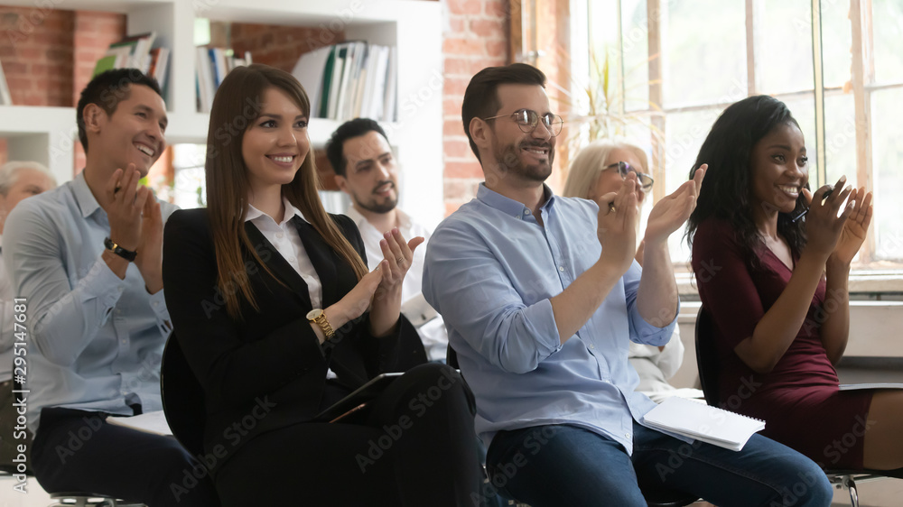 Happy diverse employees applaud thanking speaker for lecture Happy diverse employees applaud thanking speaker for lecture