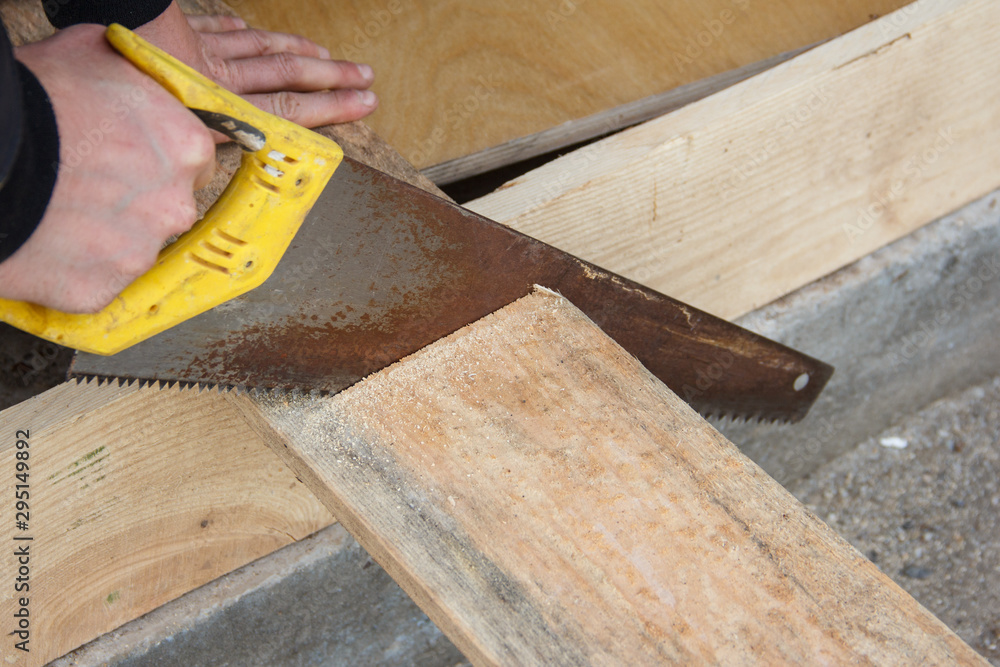 Worker cuts a piece of wooden board. Carpentry work. Worker cuts a piece of wooden board. Carpentry work.