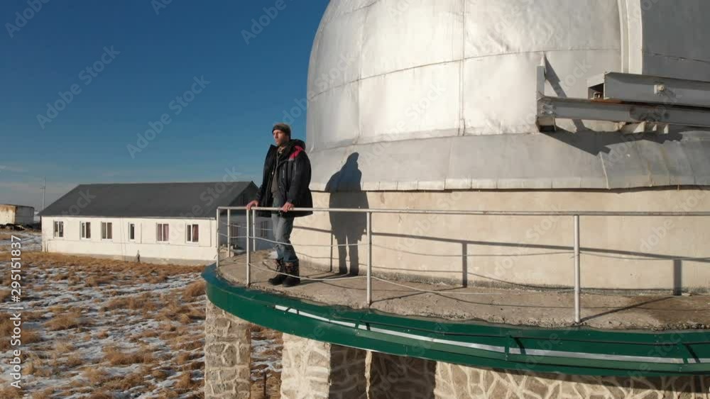 An adult male observatory worker stands on the observation deck of the ...