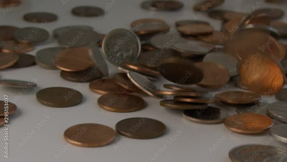 Slow motion of US coins falling on table and penny flipping