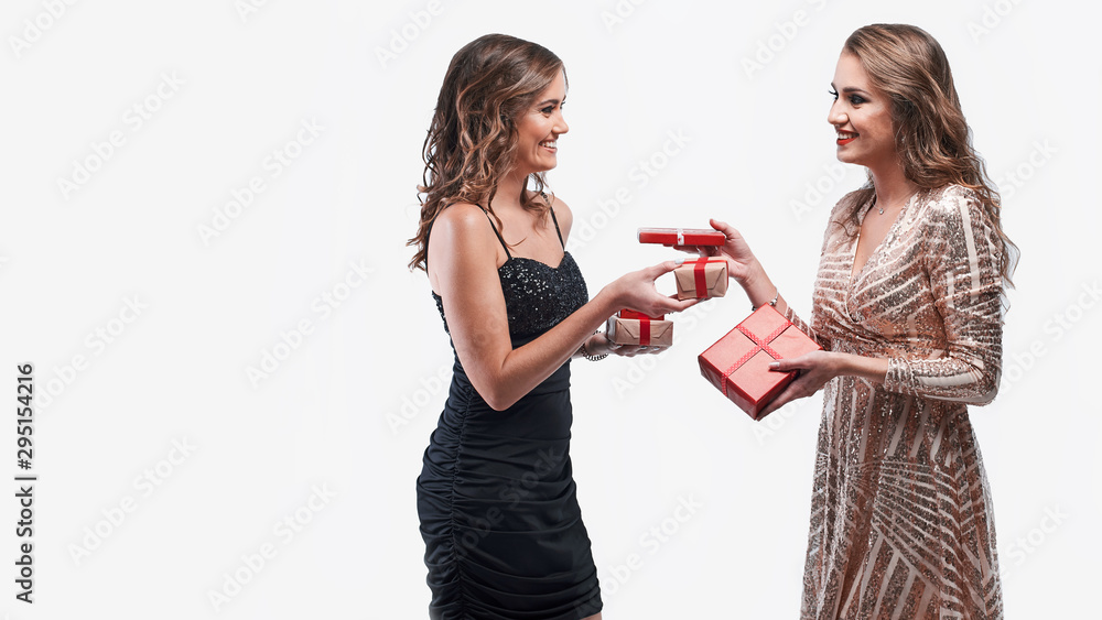 Happy girls friends exchanging presents isolated on white background. Happy girls friends exchanging presents isolated on white background.