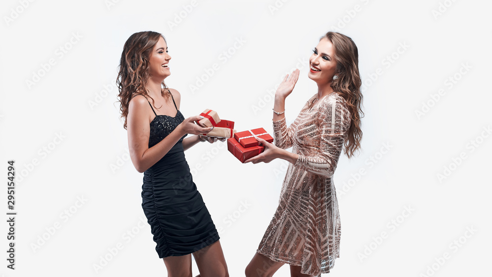 Two happy women friends exchanging presents isolated on white background. Two happy women friends exchanging presents isolated on white background.