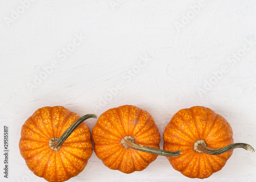 three pumpkins  on white rustic  background